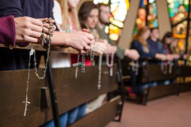 students holding rosaries in Christ the King Chapel